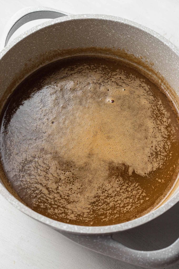 An overhead view of apple cider sauce in a saucepan.