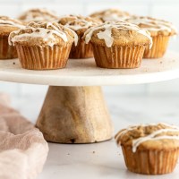 Apple muffins on top of a marble cake stand.