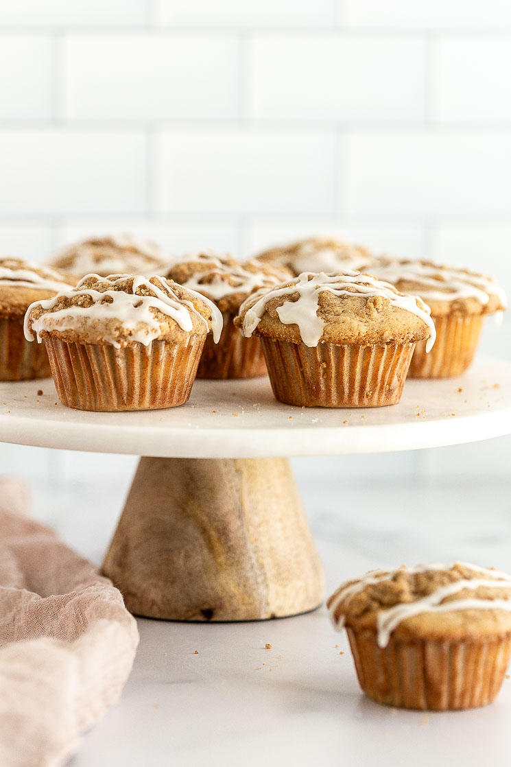 Apple muffins sitting on top of a marble cake stand.