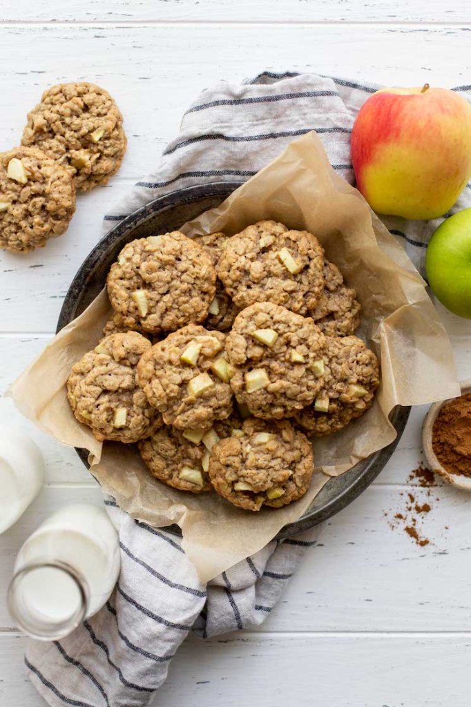 An antique metal baking dish lined with parchment paper and filled with cookies.