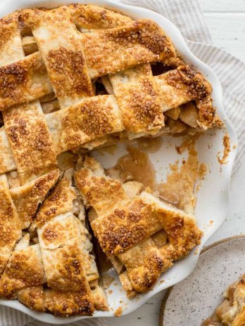 An overhead view of an apple pie with one piece removed.