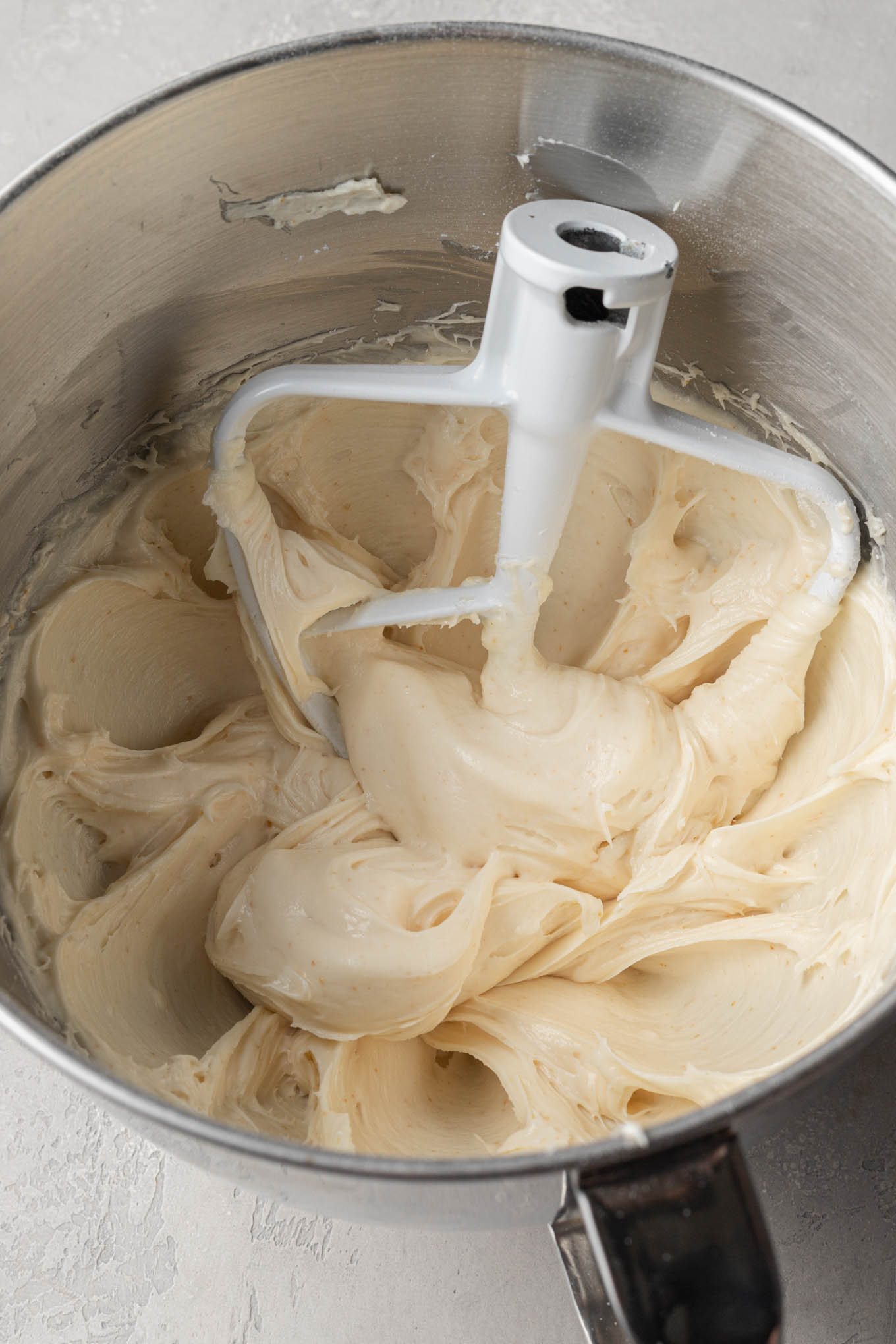 Brown butter cream cheese frosting in the bowl of a stand mixer.