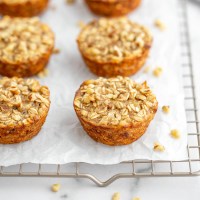 Baked banana oatmeal cups lined up on a cooling rack.