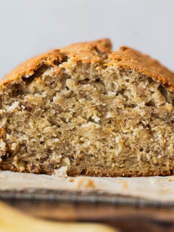 A straight on shot of a loaf of banana bread with the end cut off to show the breads texture.