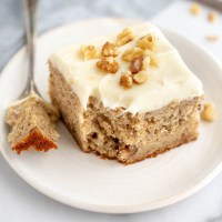 A slice of banana cake with a piece taken out of it.