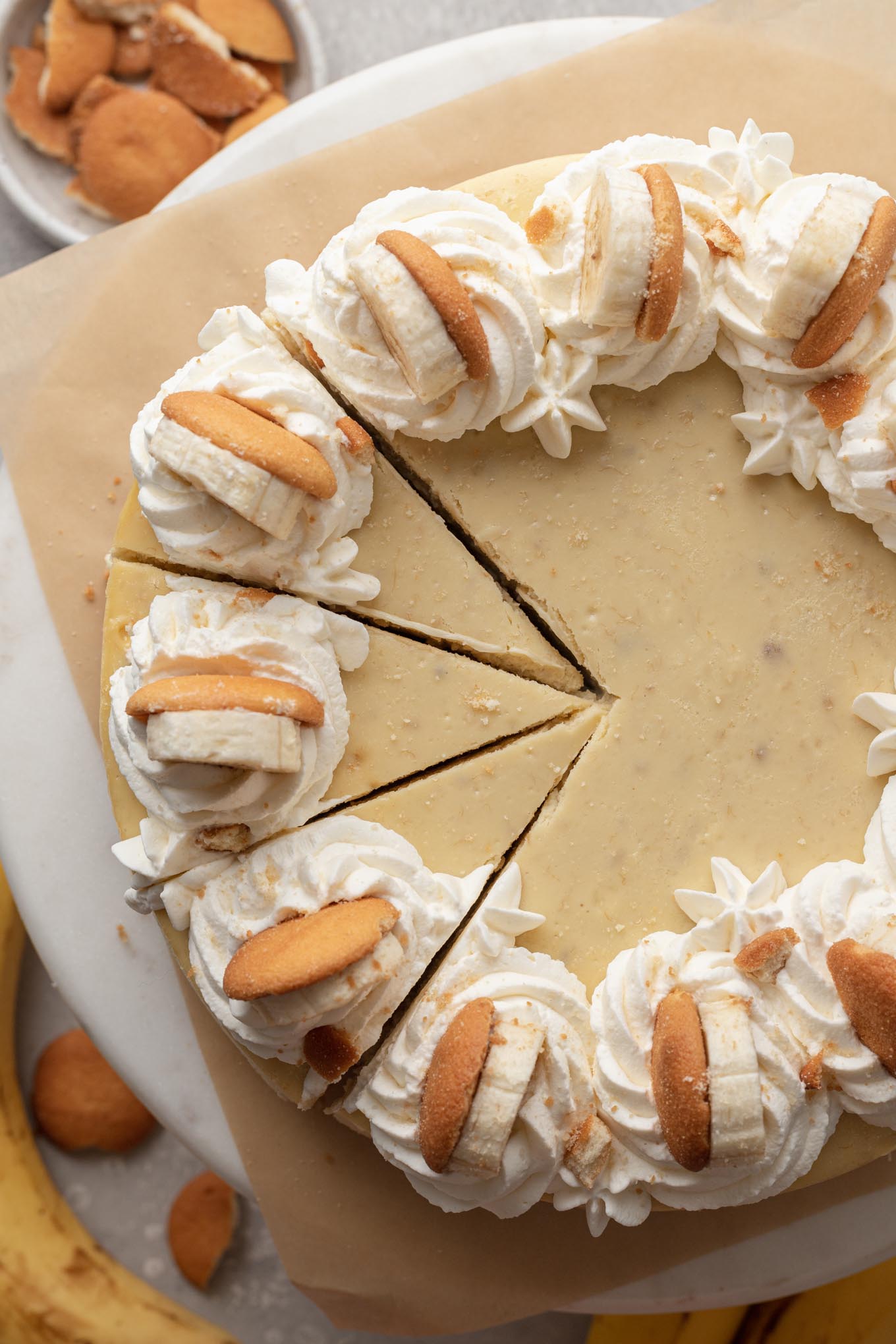 An overhead view of a banana pudding cheesecake. Three slices have been cut. 