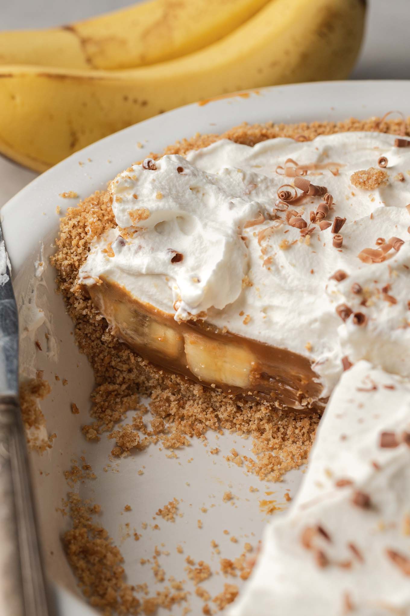 A cross-section of a banoffee pie, with slices missing from the pie plate. 