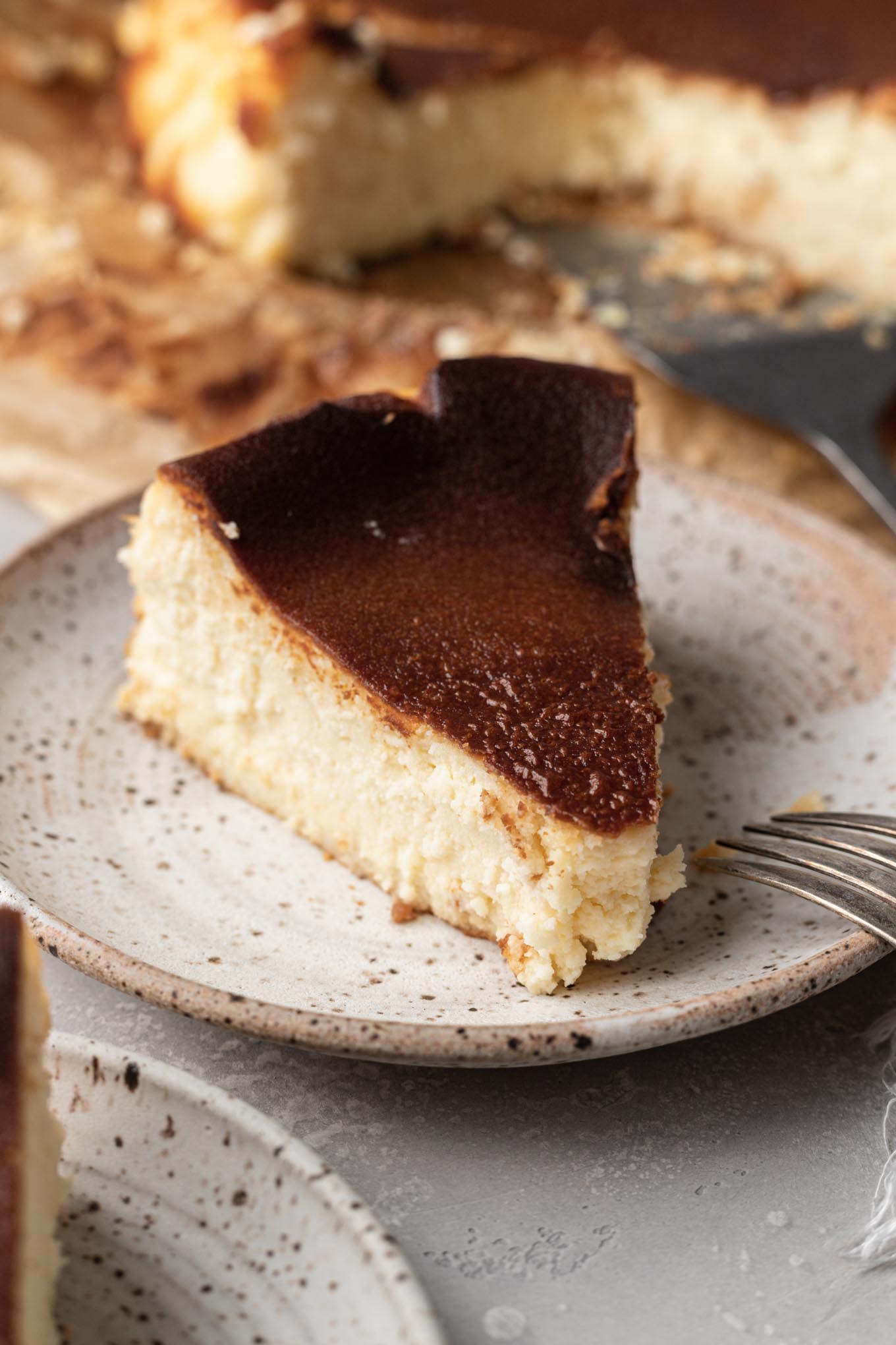 A slice of burnt Basque cheesecake on a plate. 