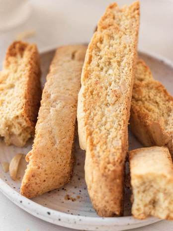 A few slices of biscotti on a white speckled plate.