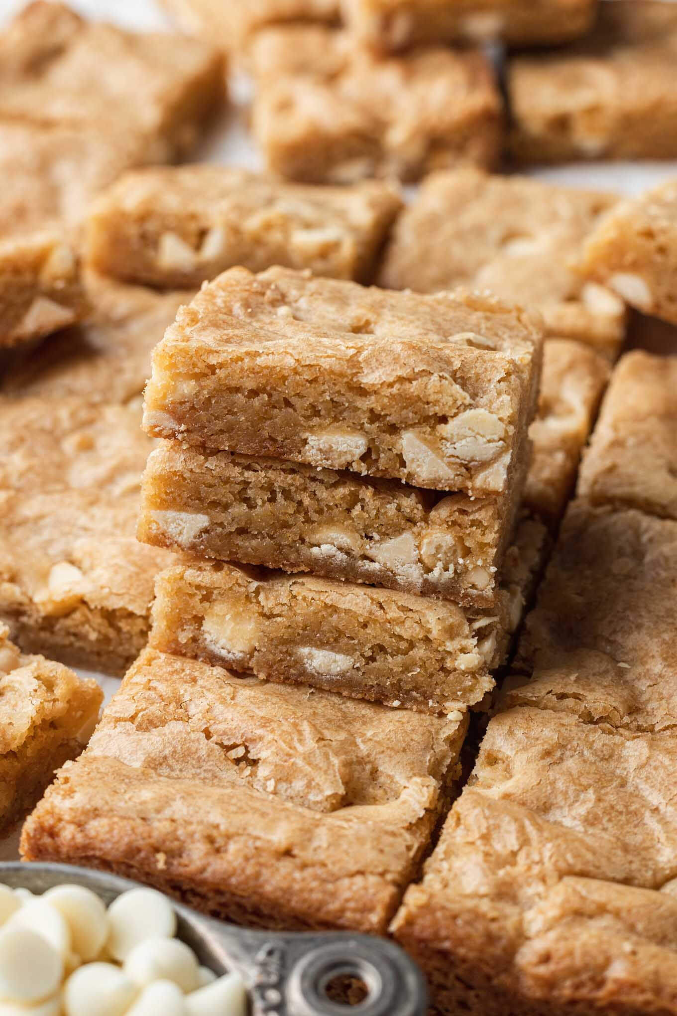 Sliced blondies with a stack of three bars piled in the foreground. 