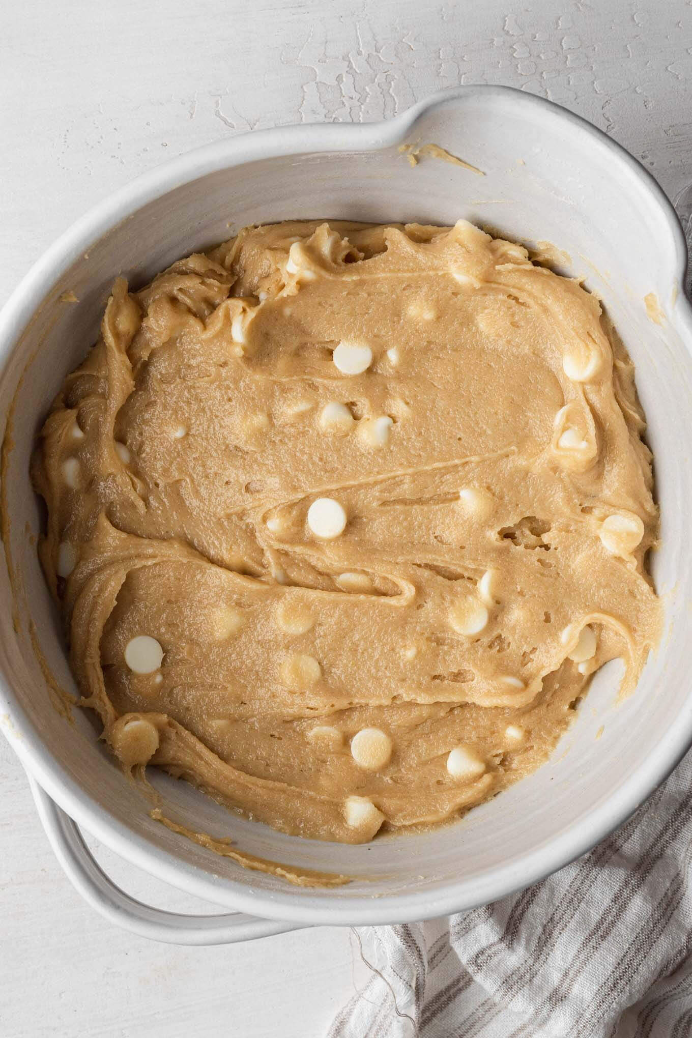 An overhead view of blondie batter in a white mixing bowl.
