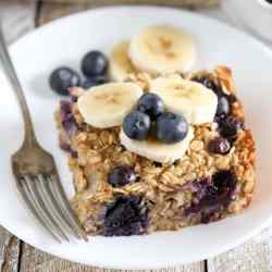 A slice of blueberry banana baked oatmeal on a white plate.