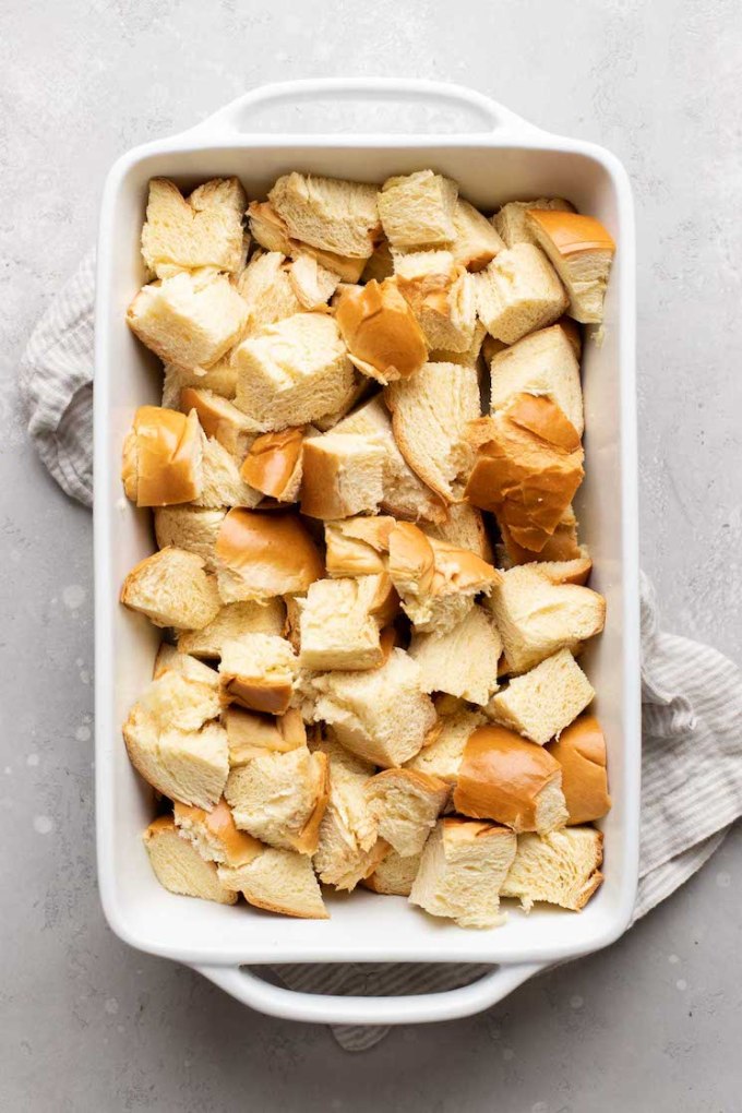 A white 9x13 pan filled with cubed bread.