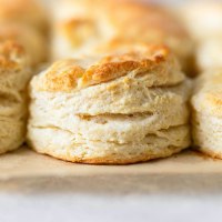 A close-up view of buttermilk biscuits on a baking sheet.