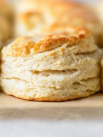 A close-up view of buttermilk biscuits on a baking sheet.