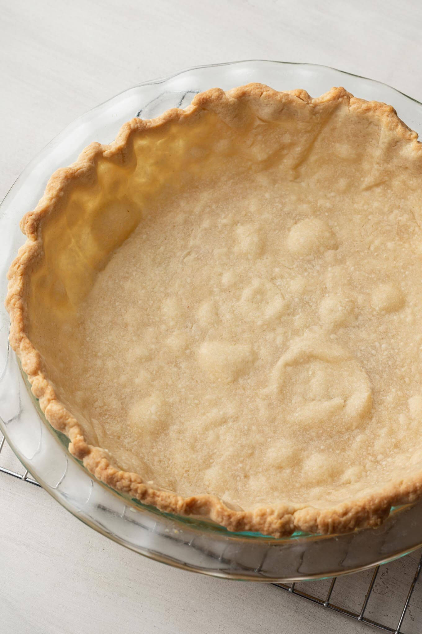 A blind baked pie crust in a glass pie plate. 