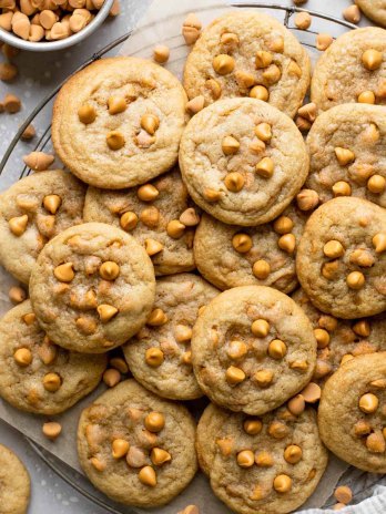 An overhead view of butterscotch cookies piled on a wire cooling rack.