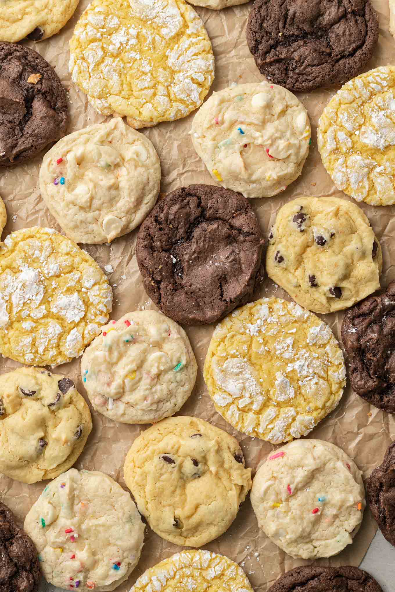 An overhead view of cake mix cookies of all flavors, on parchment paper. 