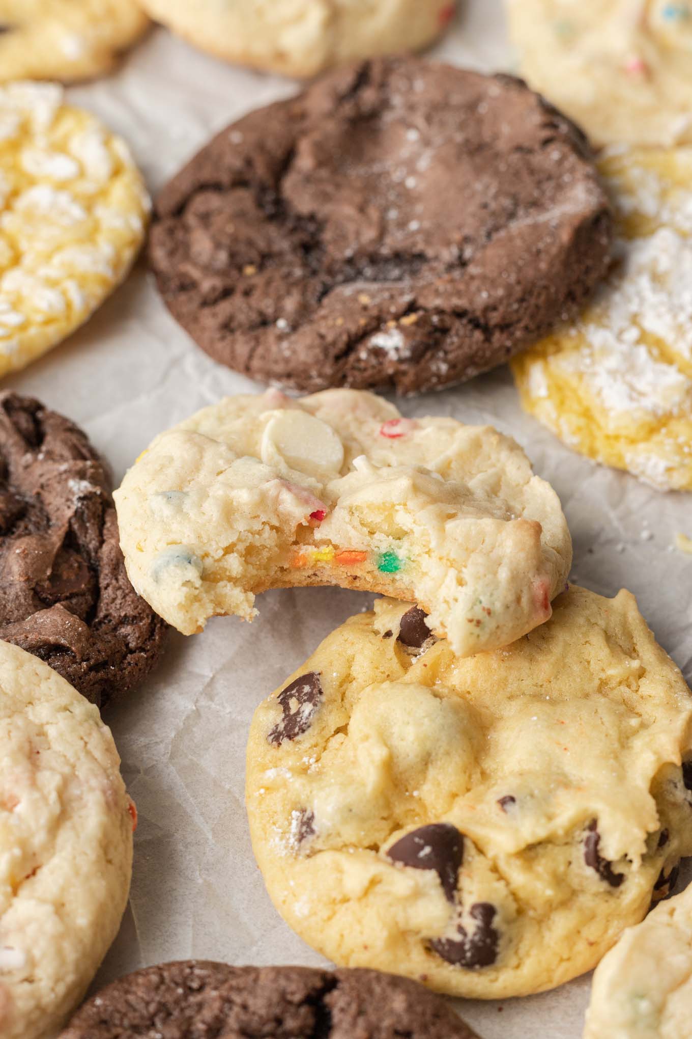 Different flavors of cookies on parchment paper. 