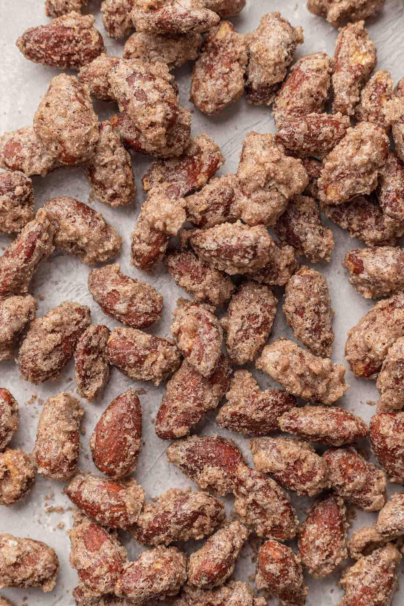 An overhead view of cinnamon sugar almonds on parchment paper. 