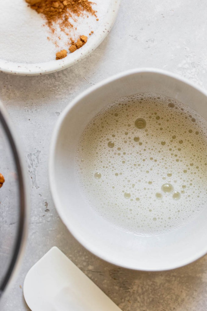 An egg white in a bowl mixed with water until frothy.