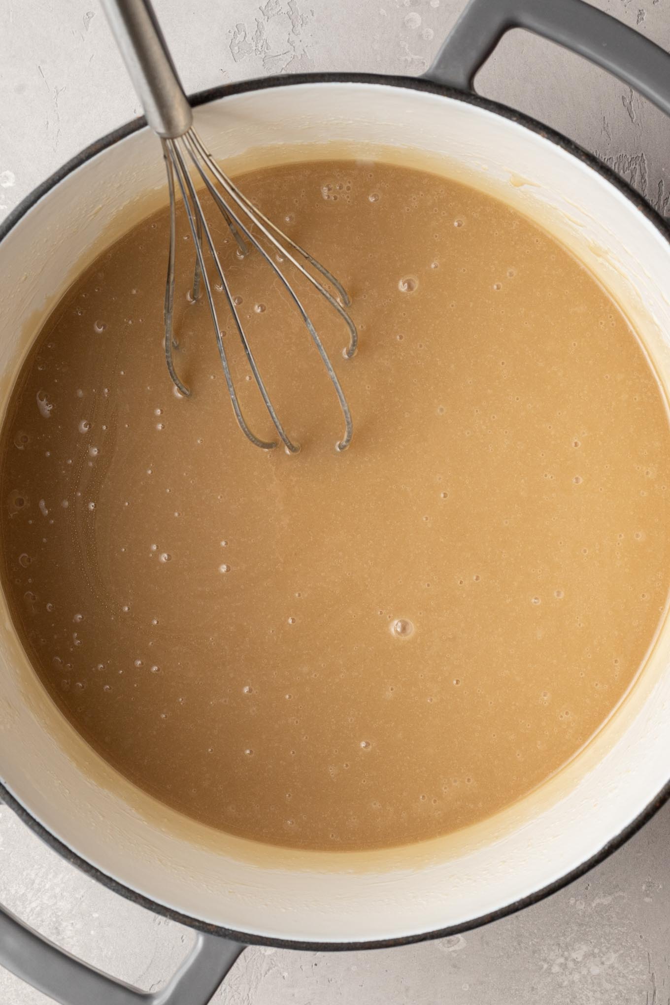 An overhead view of uncooked caramel in a saucepan.