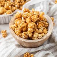 A small wooden bowl filled with caramel corn.