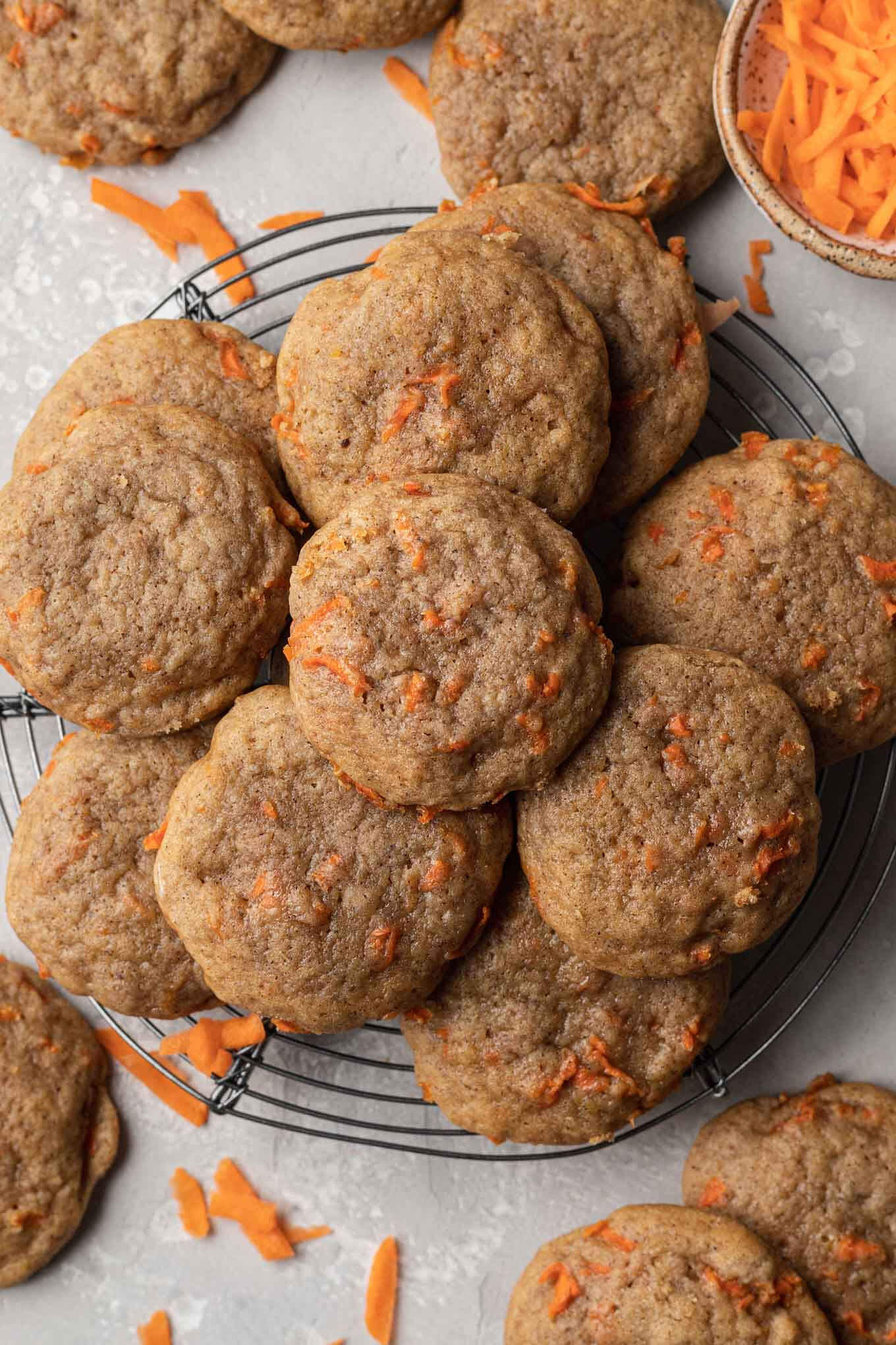 An overhead view of unfrosted carrot cookies on a wire cooling rack. 