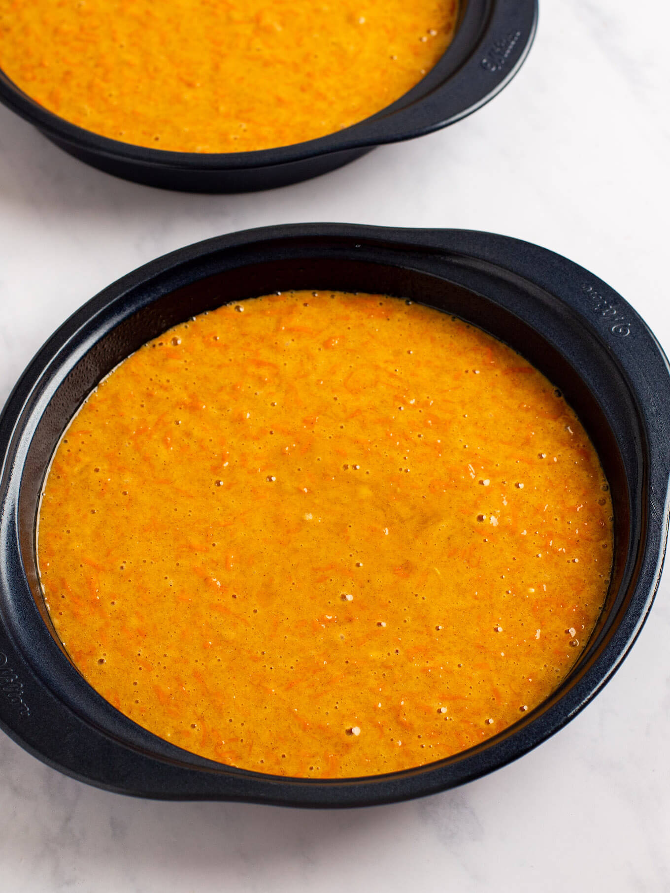 Carrot cake batter poured into two 9-inch round cake pans.