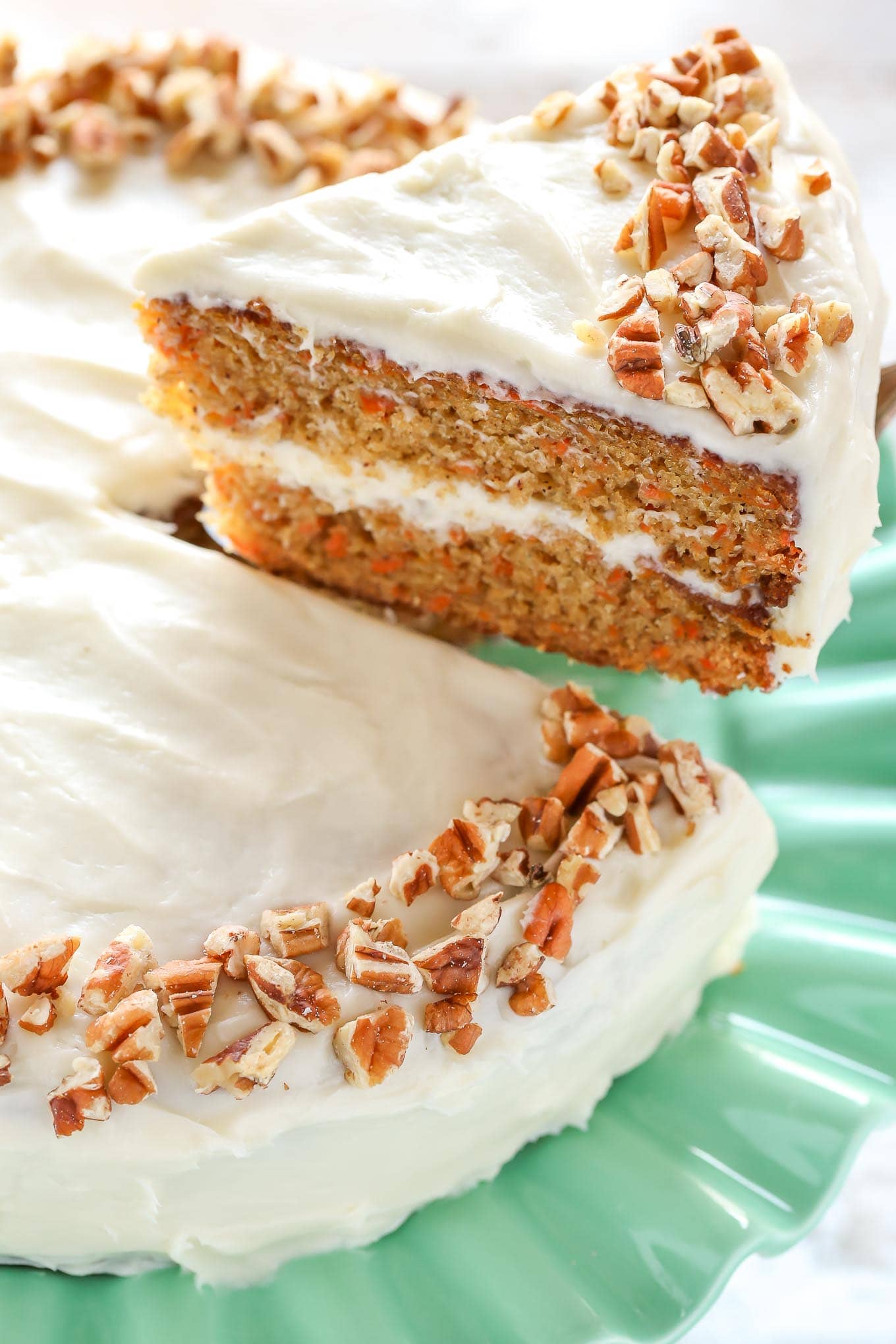A slice of carrot cake being lifted up to show the texture.