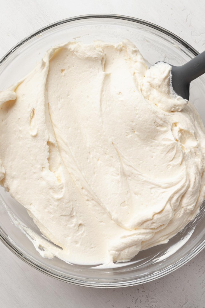 An overhead view of chantilly cake frosting in a bowl.