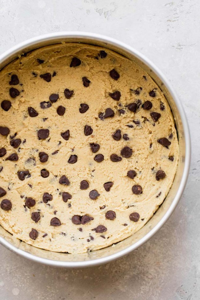 Cookie cake batter pressed into the bottom of a springform pan.