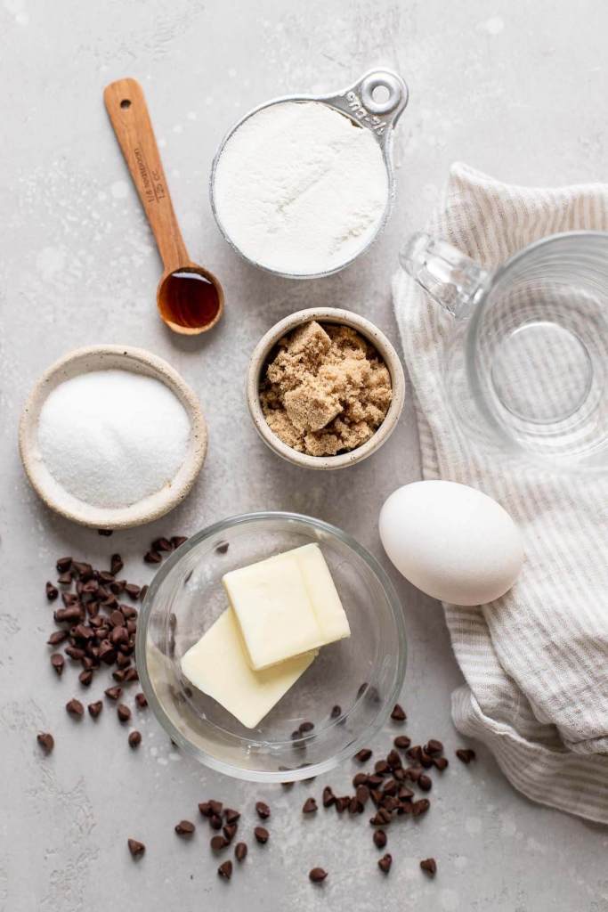 An overhead view of the ingredients needed to make a microwave chocolate chip cookie.