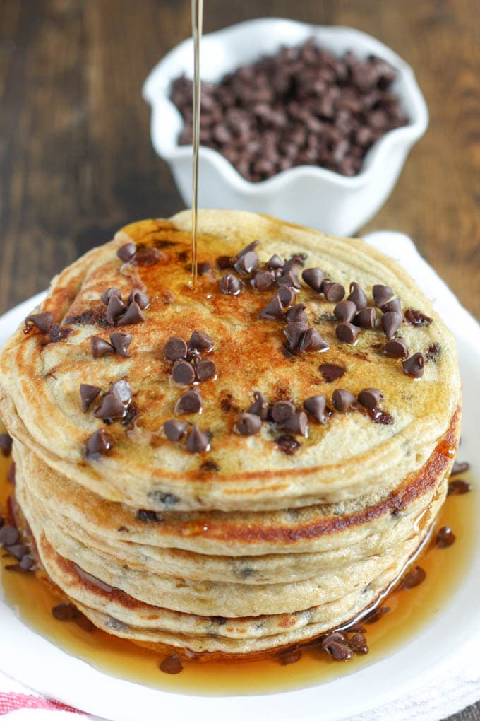 A stack of healthy pancakes being drizzled with maple syrup. 