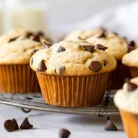 Several muffins sitting on top of an antique wire rack.