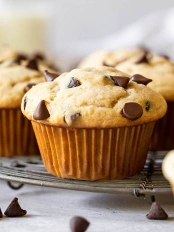 Several muffins sitting on top of an antique wire rack.