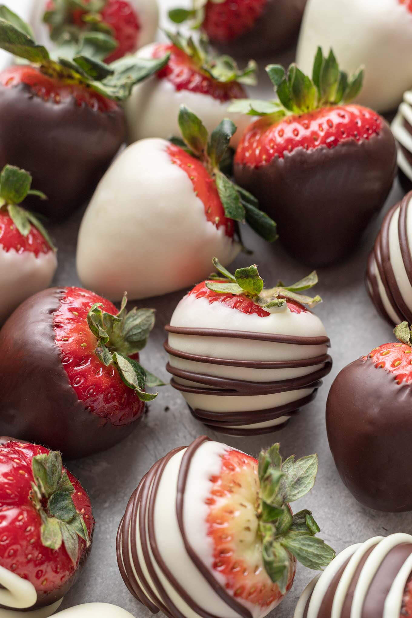 Chocolate coated strawberries on a piece of parchment paper.
