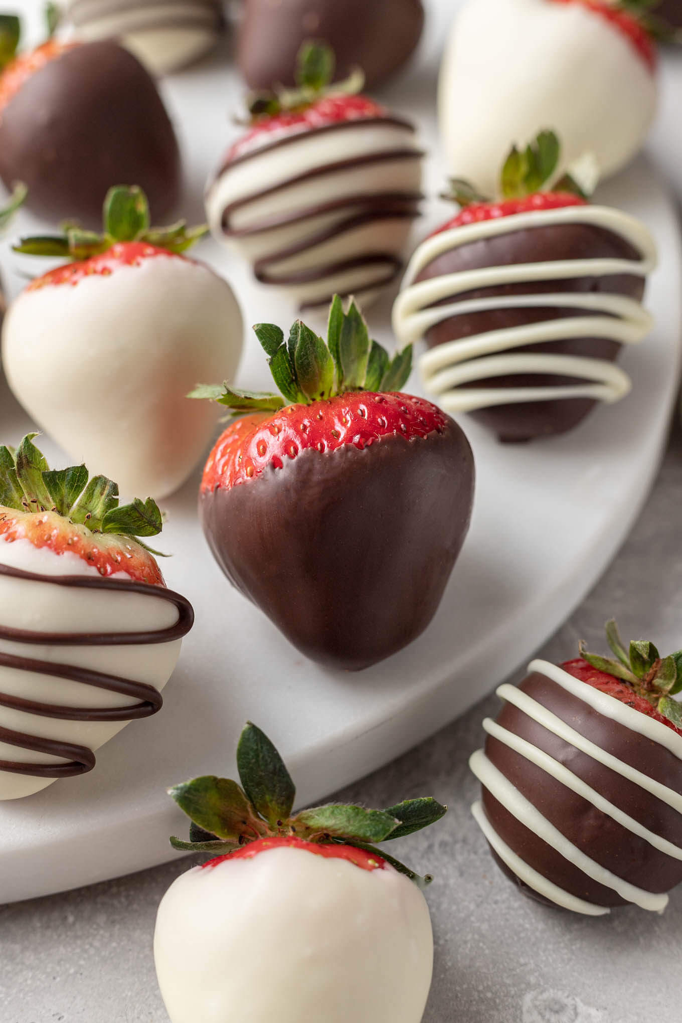 A mixture of semi-sweet and white chocolate covered strawberries. 