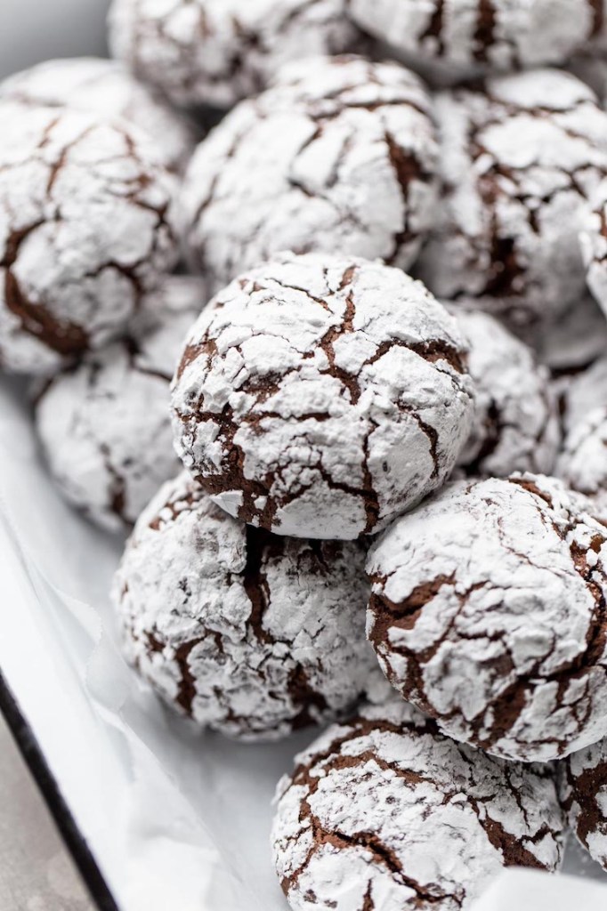 A serving dish filled with chocolate crinkle cookies.