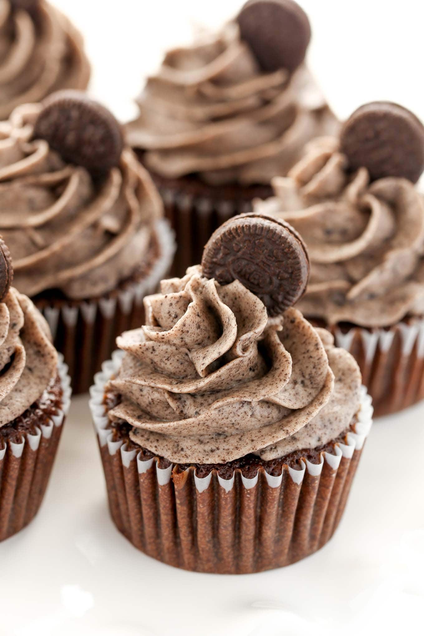 Four oreo cookie cupcakes garnished with Oreo buttercream and mini Oreos. 