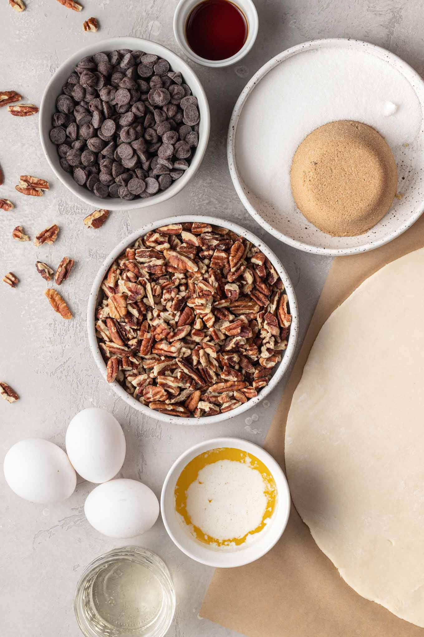 An overhead view of the ingredients needed to make chocolate chip pecan pie. 