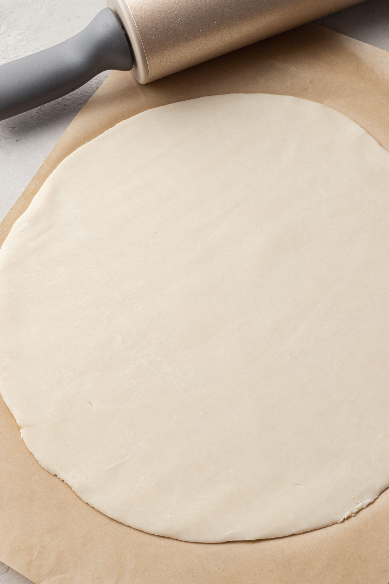 An overhead view of pie dough rolled into a circle. 