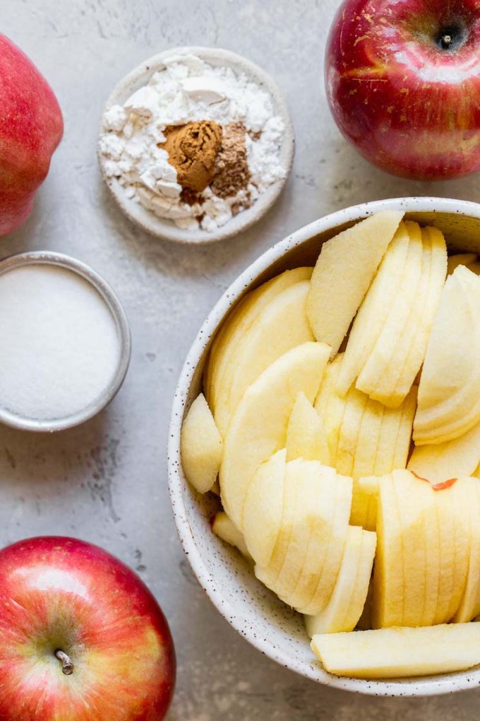 Apple crisp ingredients laid out on a rustic gray surface.