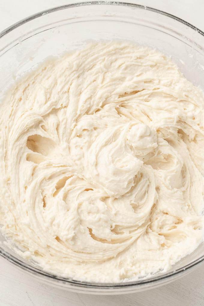 An overhead view of cake batter in a glass mixing bowl.