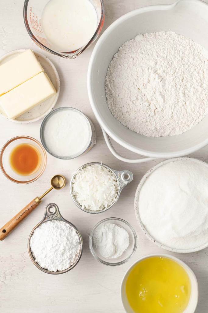 An overhead view of the ingredients needed to make a coconut cake from scratch. 