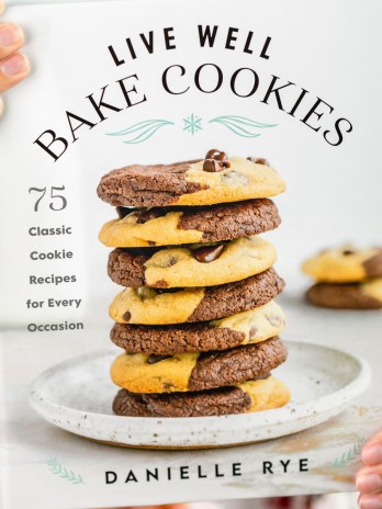 An image of the cookbook Live Well Bake Cookies being held in front of a camera.