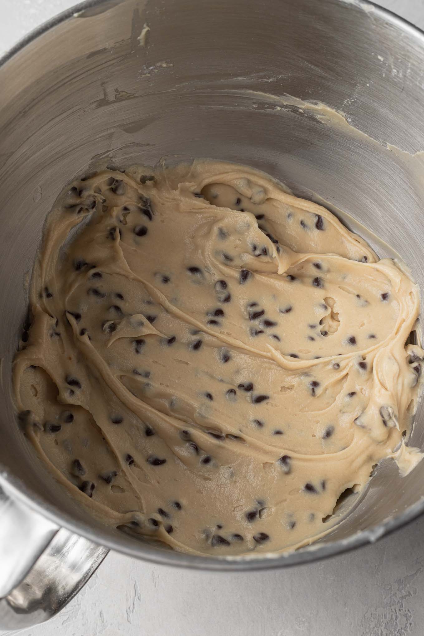 Cookie dough dip in a stainless steel mixing bowl. 