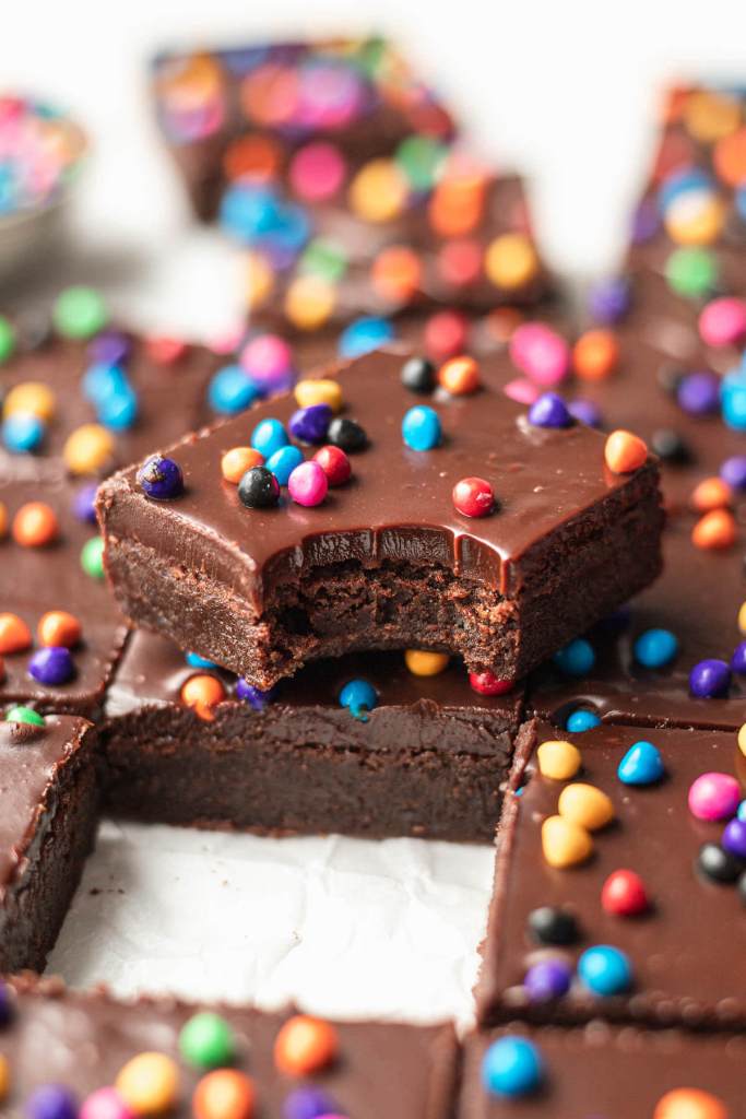 An angled view of cosmic brownies. One is stacked on another and has a bite taken out of it.