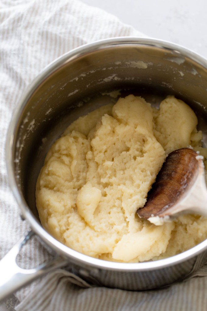 Overhead view of choux pastry dough in a large saucepan.