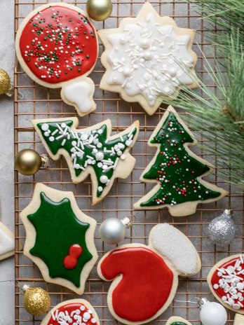 A cooling rack filled with decorated cut out sugar cookies.